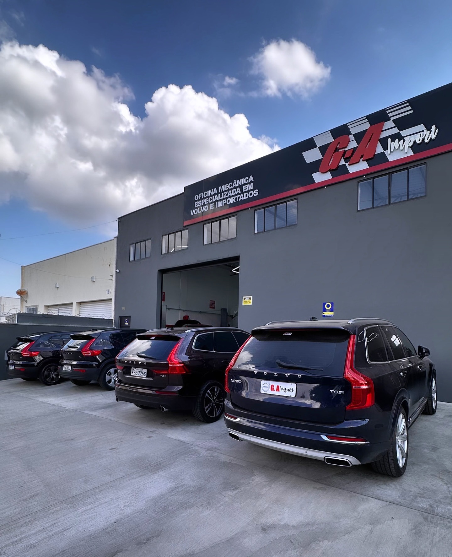 Fachada da oficina G.A Import com Volvos estacionados